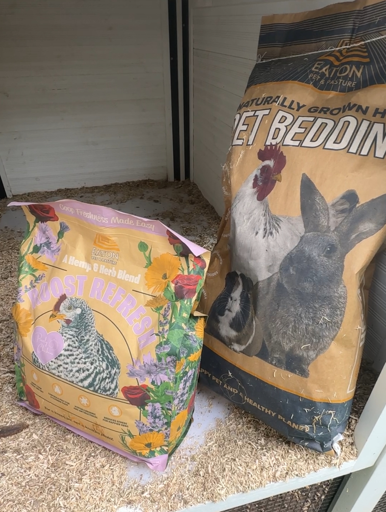 photo of chicken coop supplies from eaton pet and pasture. Hemp bedding and coop refresh paper bags with labels showing clearly.