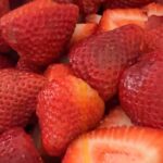 Bowl of fresh strawberries hulled and ready for jam
