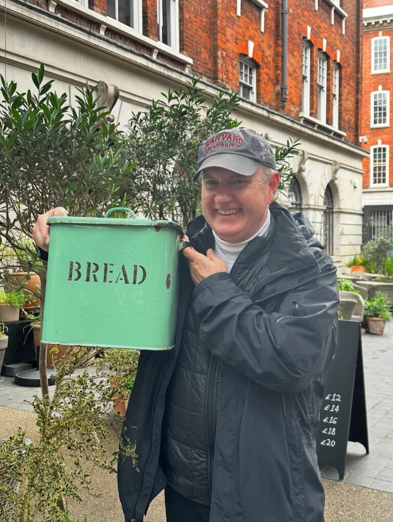 Lane Morris standing beside a green Bread sign on a London street