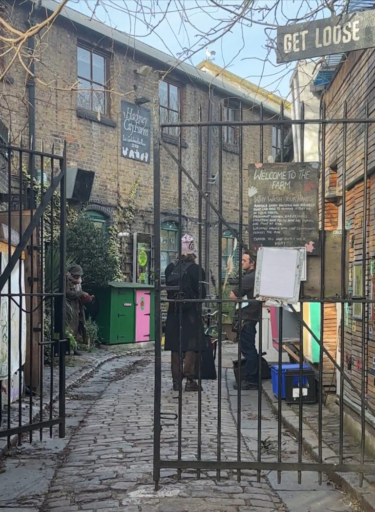View through an iron gate into a narrow London alley