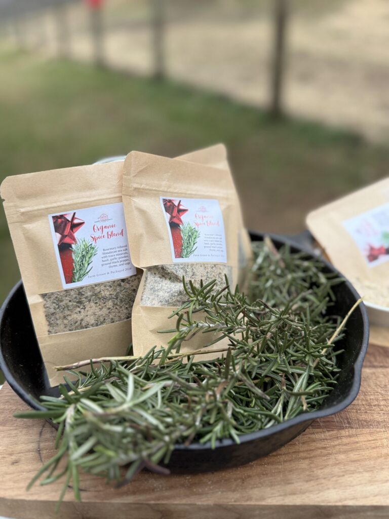 Bags of homemade rosemary herb seasoning salt with fresh rosemary sprigs on a tray