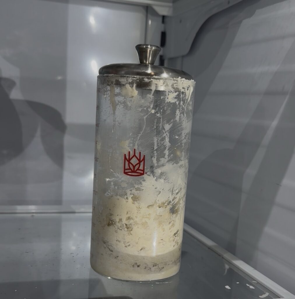 Sourdough starter jar in the refrigerator before a trip