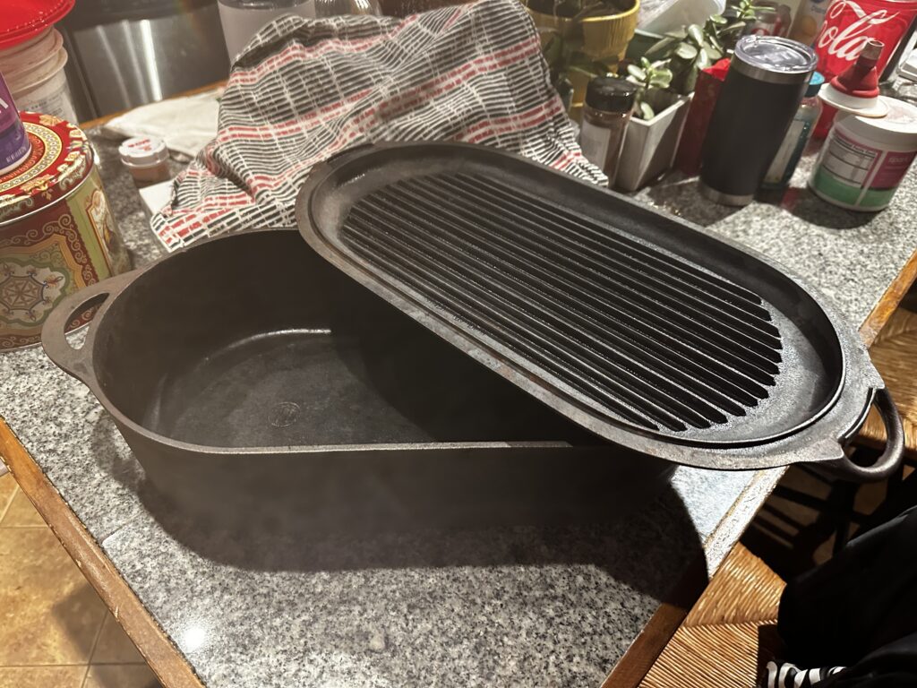 Restored cast iron dutch oven on the counter with its ribbed grill pan lid resting across the top