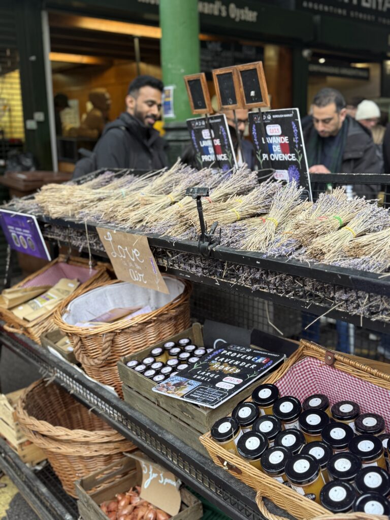 Bundles of dried Provencal lavender above baskets of lavender honey jars at a Borough Market stall