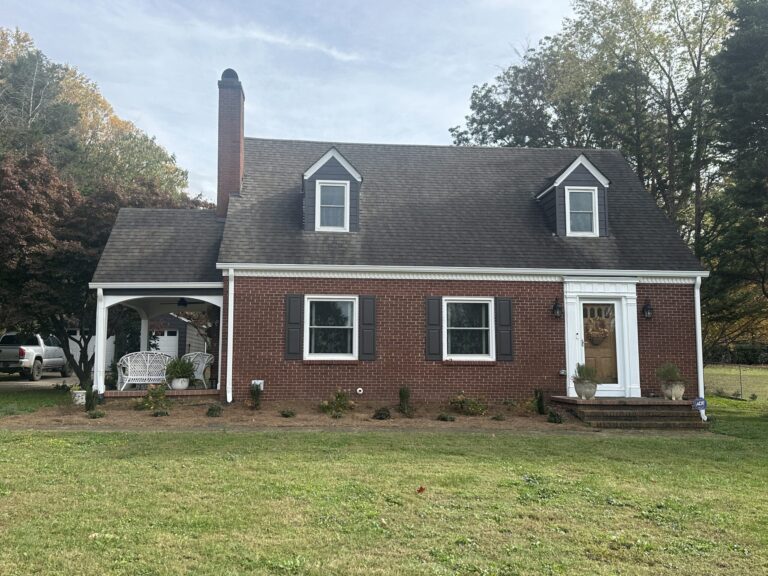 Brick cape cod house with fresh landscaping along the front