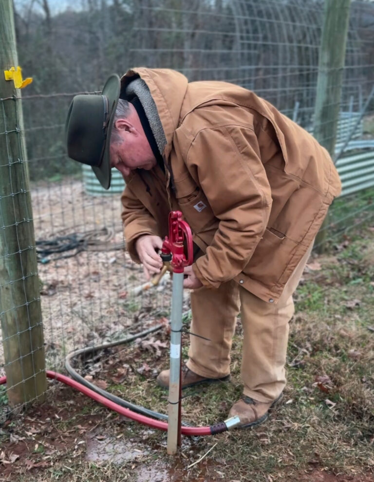 Lane Morris working on fencing in a canvas jacket on a cold day