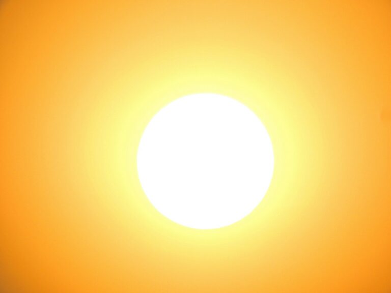 A white-hot sun burning in a cloudless amber sky during a heat wave