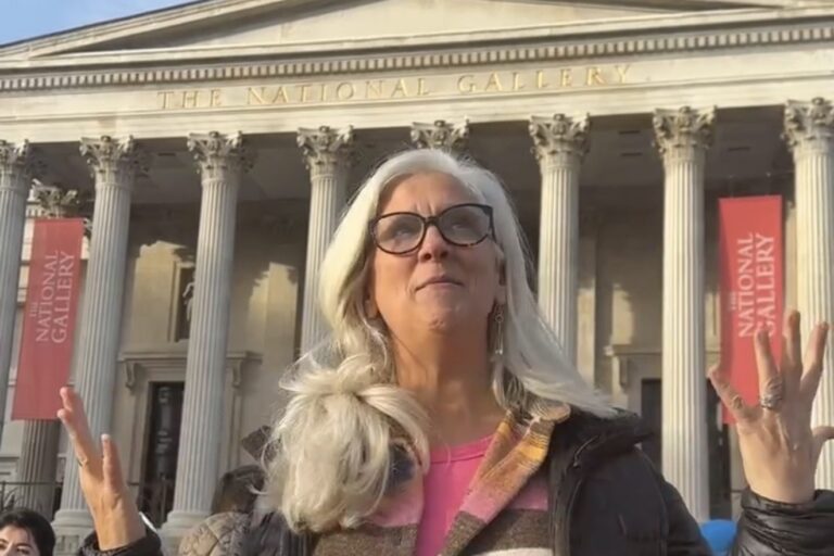 Jules Morris smiling up at the sky in front of the columns of the National Gallery in London